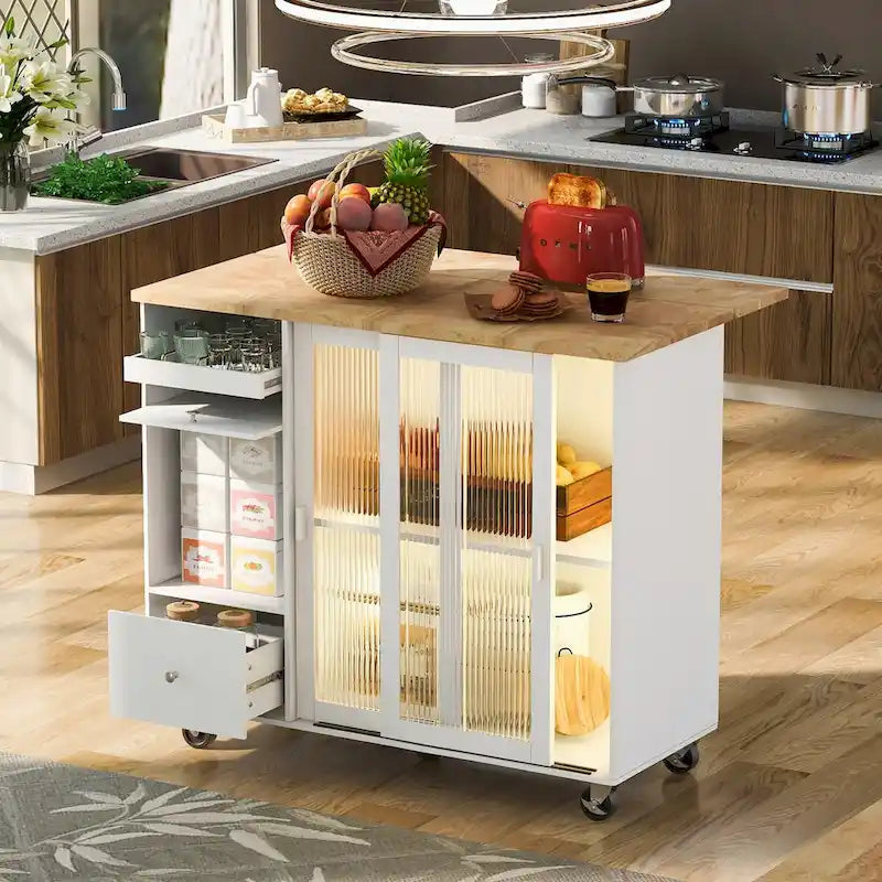 Isla de cocina con superficie abatible, luz LED, puertas de vidrio estriado, estante ajustable, dos cajones y ruedas